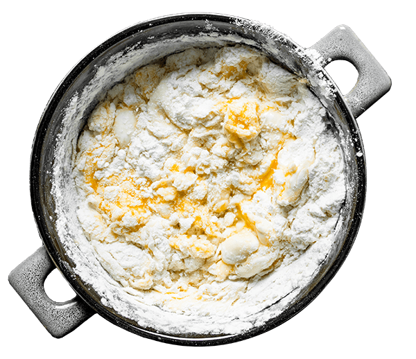 A mixing bowl filled with dough ingredients.