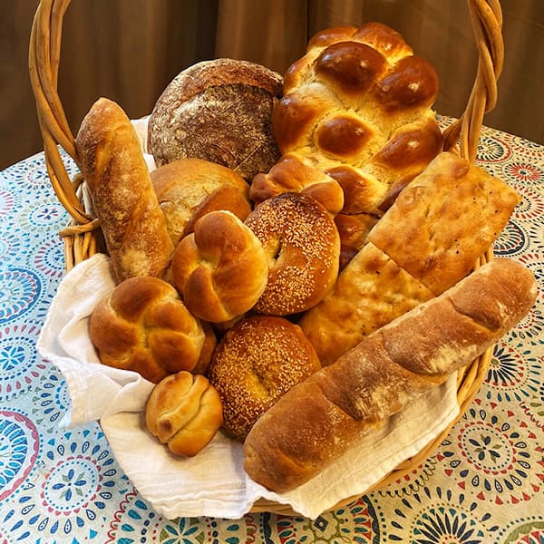 A variety of freshly baked breads in a basket, all prepared by Park City Culinary Institute students.